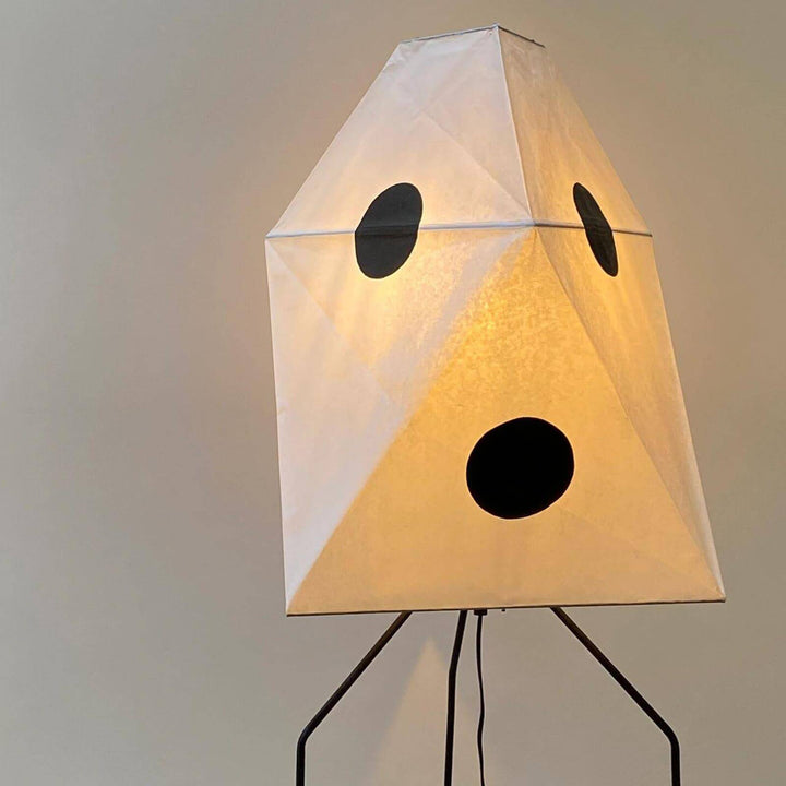 Akari UF3-Q white rice paper floor lamp with minimalist design, on tripod base, illuminating with soft light.