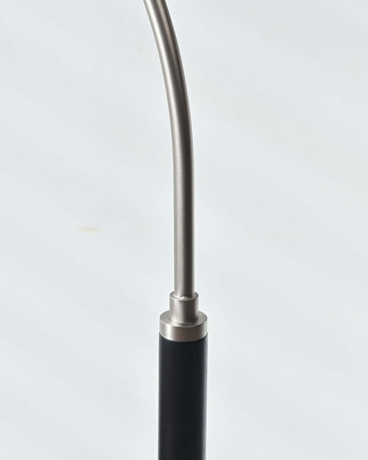 Close-up of the Nelke wooden floor lamp showcasing its sleek curved design and minimalist styling.