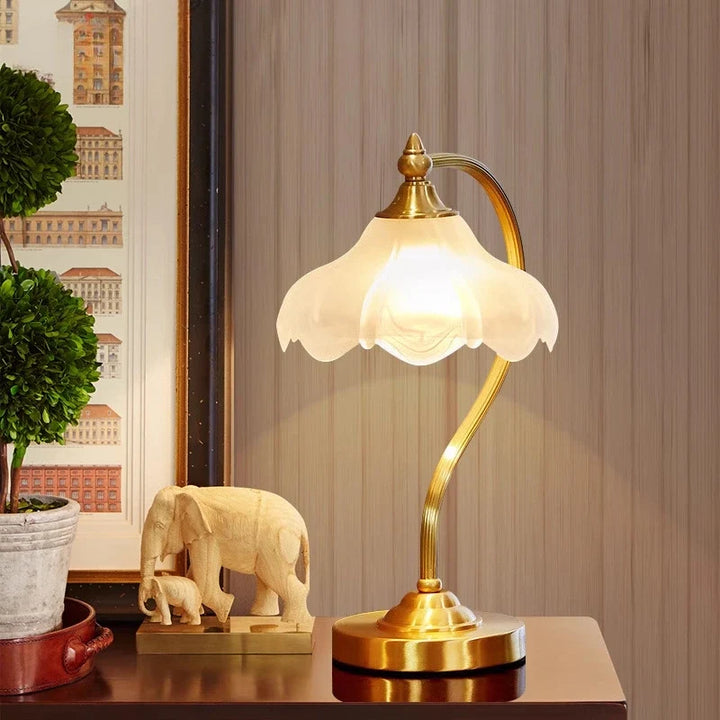 Copper Petal Glass Lamp on nightstand with warm light glowing through glass shade
