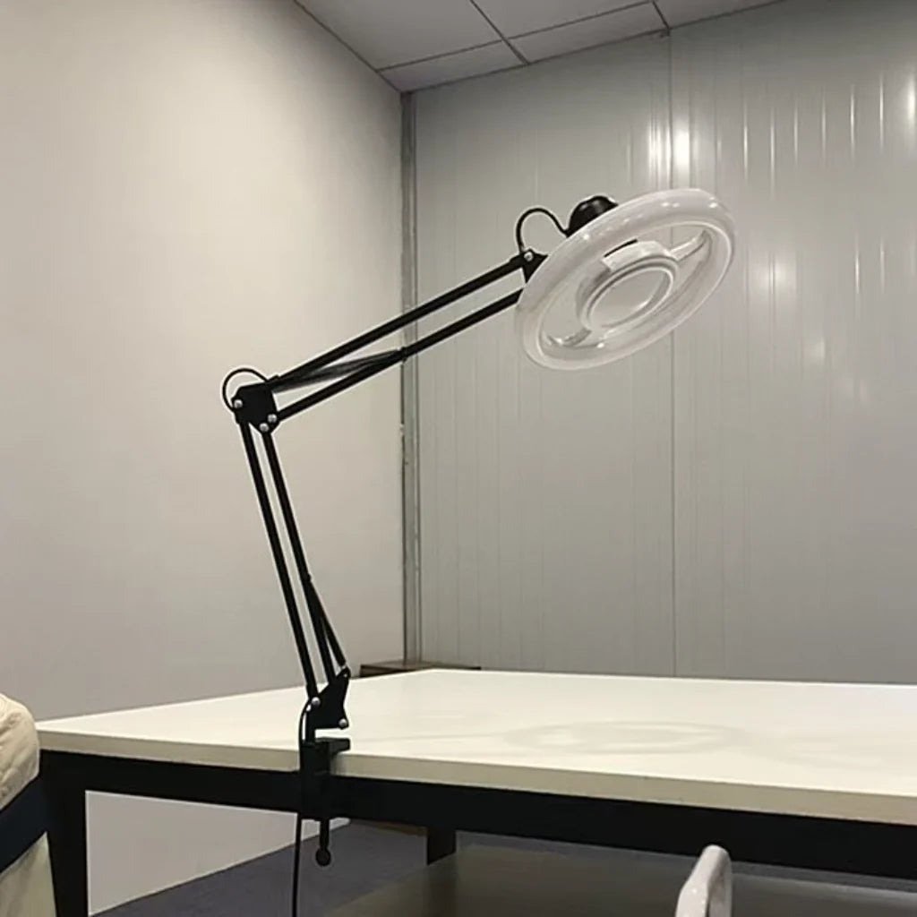 Black Adjustable LED Ring Floor Lamp clamped to desk