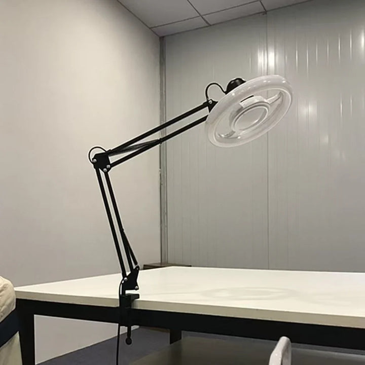 Black Adjustable LED Ring Floor Lamp clamped to desk