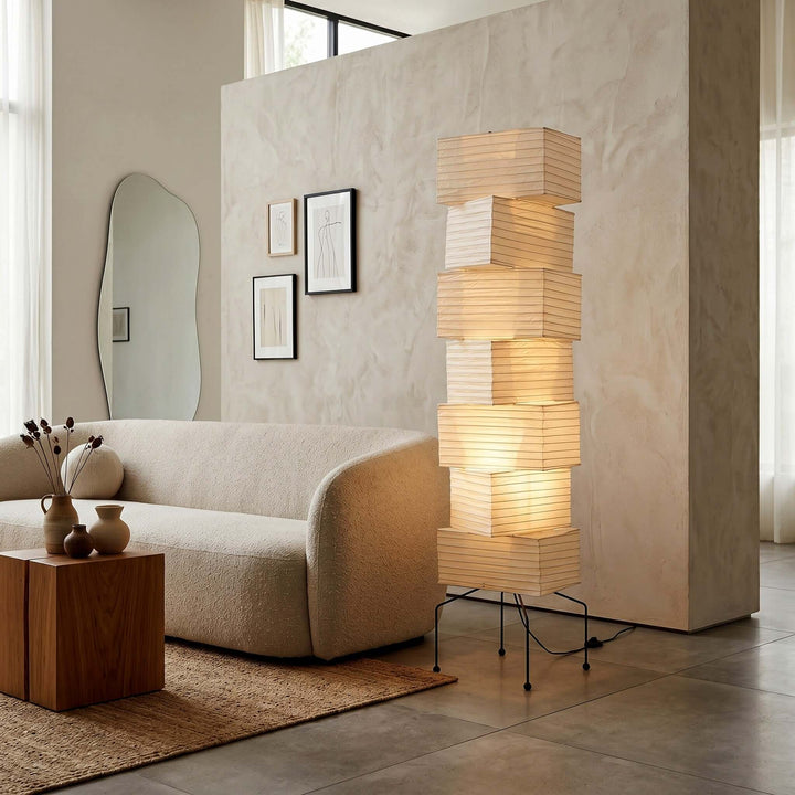 White Akari Paper Floor Lamp beside a curved sofa in a modern living room