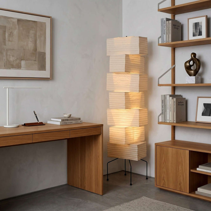 White Akari Paper Floor Lamp between a desk and bookshelf in a home office