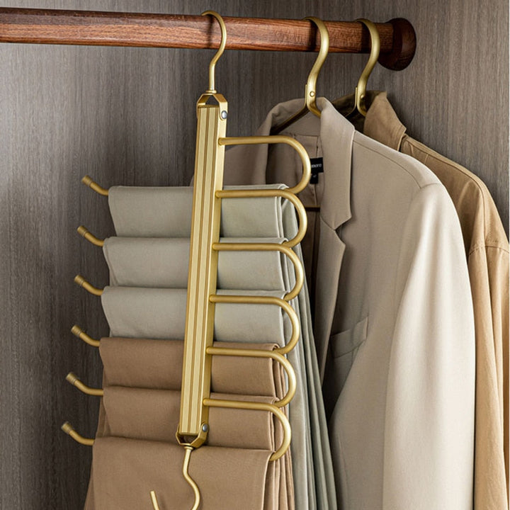 Gold Aluminum Pants Hanger holding trousers beside jackets