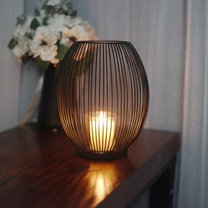 Black Iron Wire Lantern Candle Holder lit on side table