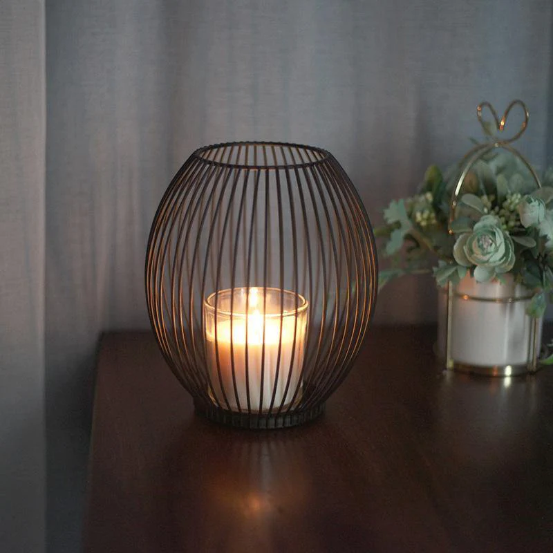 Black Iron Wire Lantern Candle Holder lit beside plant