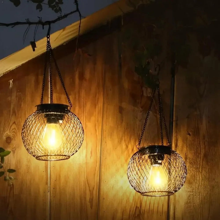 Black metal solar lantern with wire mesh globe, full view