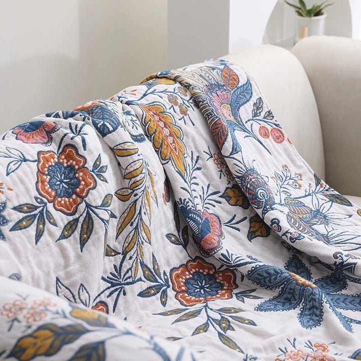 Blue botanical print cotton throw blanket, tassel edge close-up
