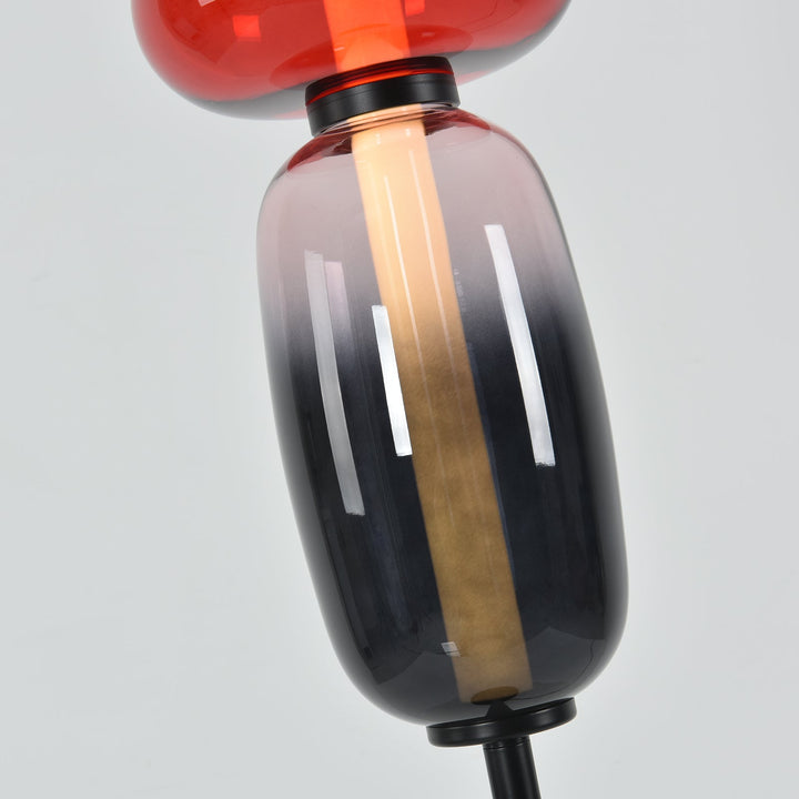 Close-up of the Candied floor lamp’s smoky lower glass shade and warm vertical illuminated core.