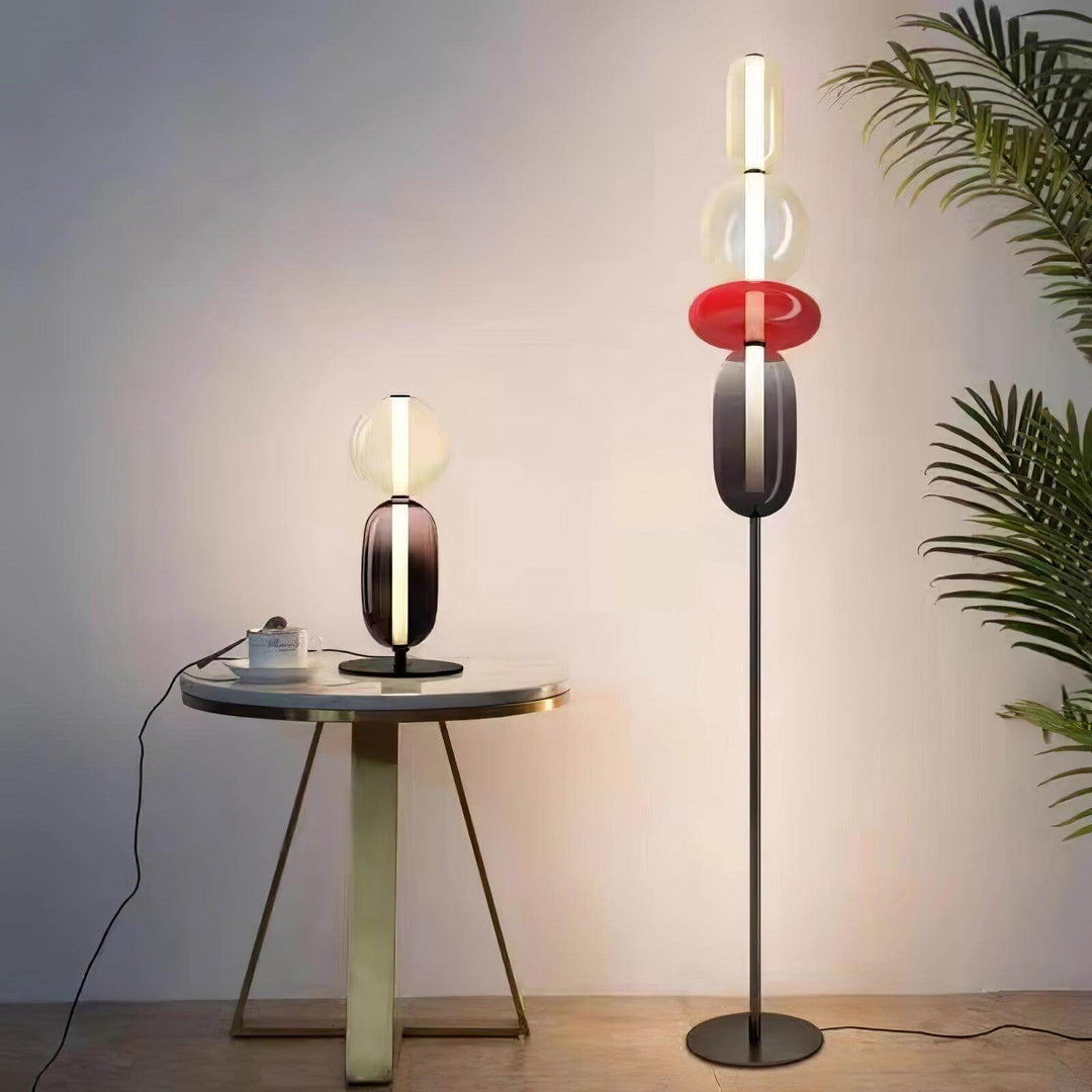 Red Candied Glass Floor Lamp and matching table lamp beside a round table and palm plant