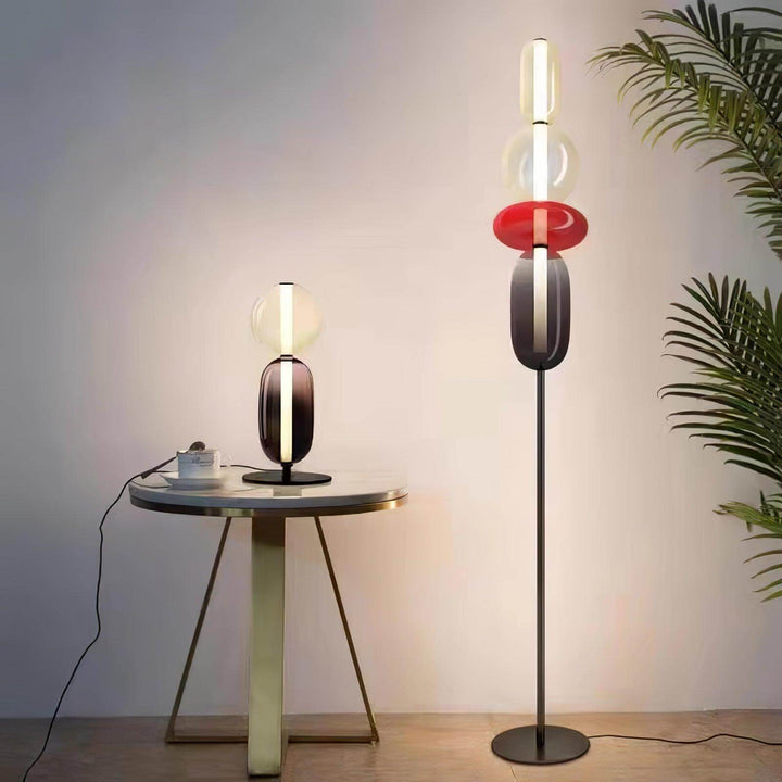 Red Candied Glass Floor Lamp and matching table lamp beside a round table and palm plant