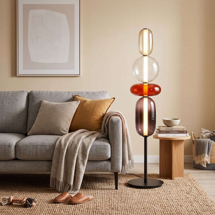 Red Candied Glass Floor Lamp casting a warm glow beside a gray sofa