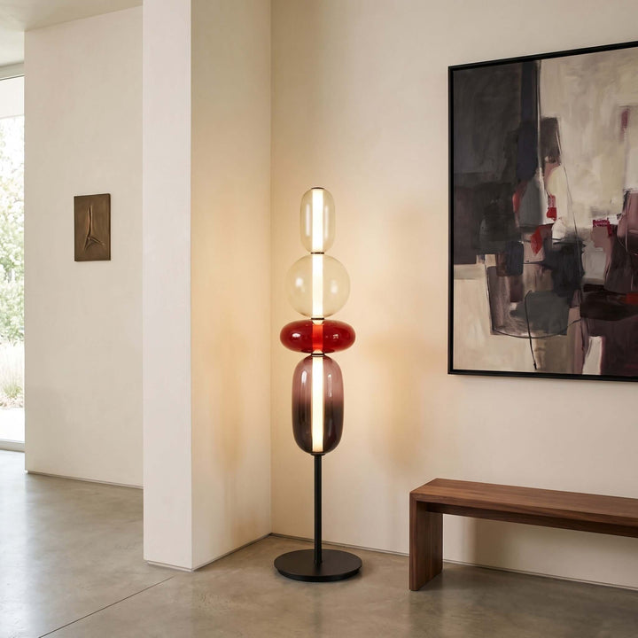 Red Candied Glass Floor Lamp beside a wood bench in a modern entryway