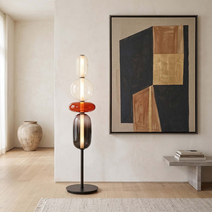 Red Candied Glass Floor Lamp glowing beneath abstract wall art