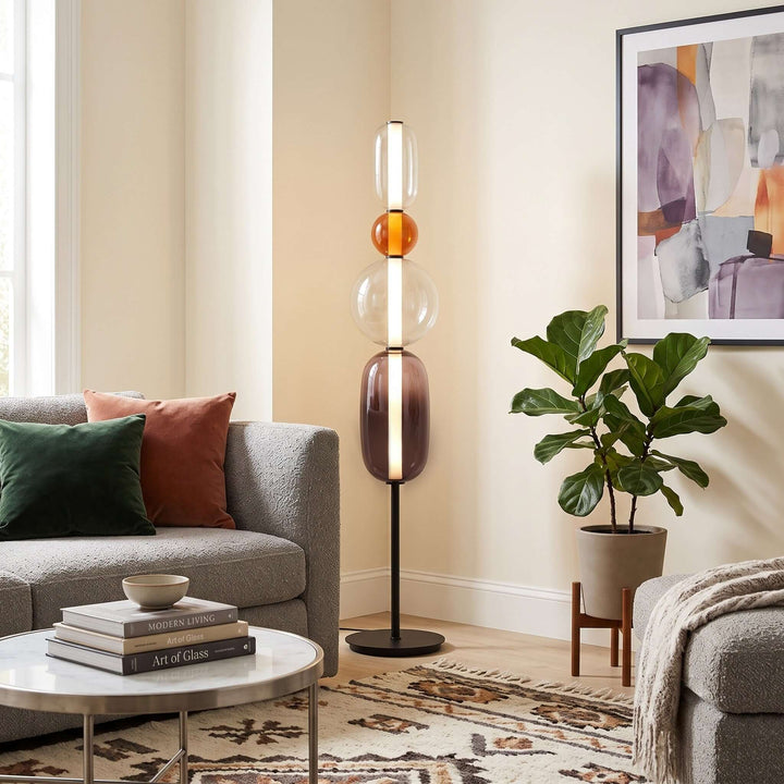 Orange Candied Glass Floor Lamp Model B beside a gray sofa and potted plant