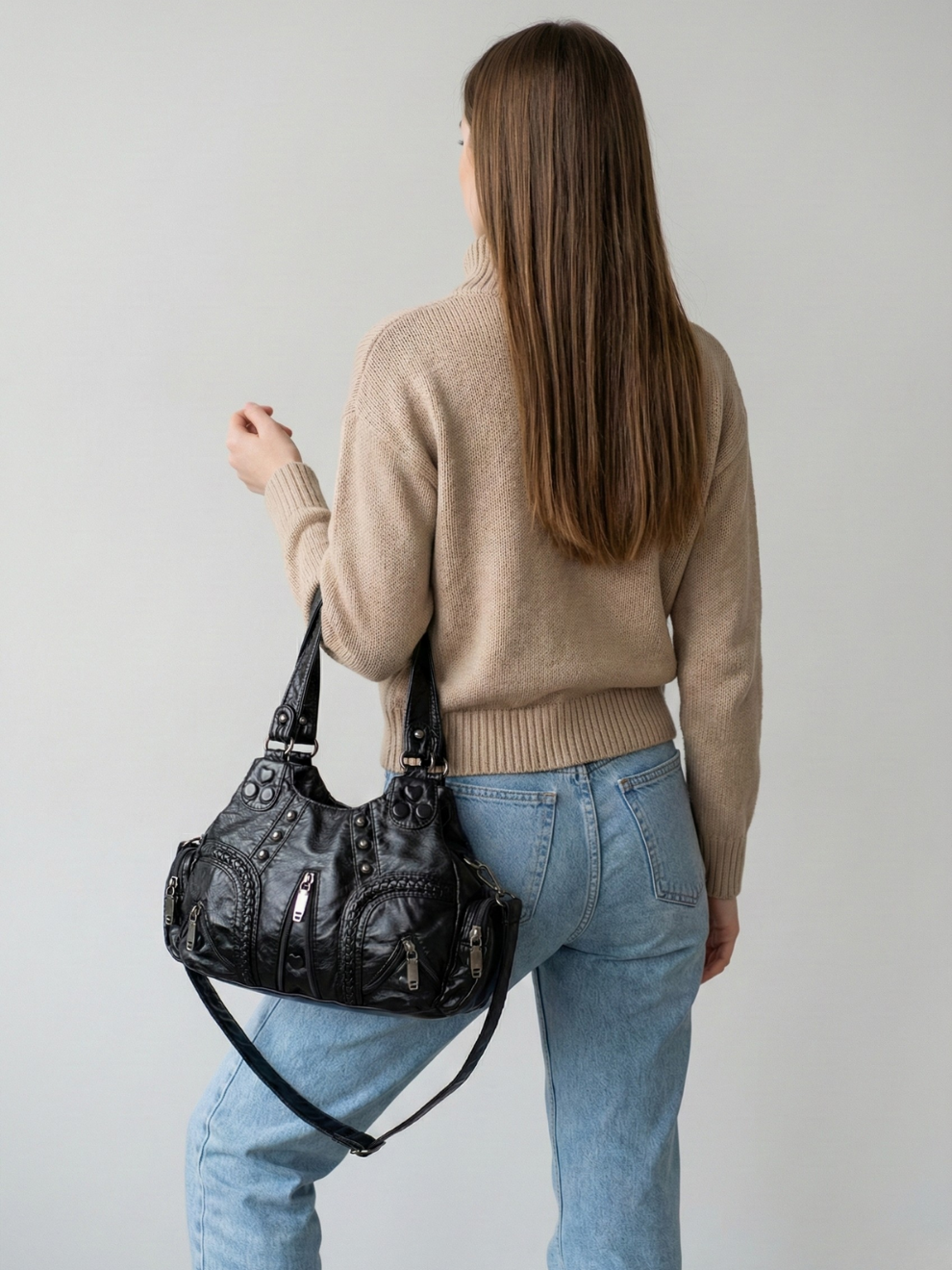 Black Compact Vegan Leather Shoulder Bag carried by hand