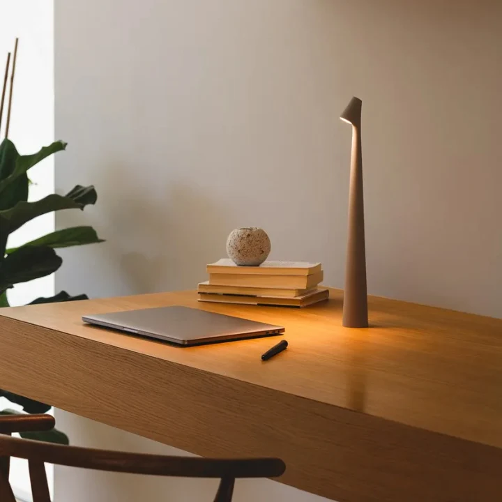 Golden Brown Cordless Cone Table Lamp lit on desk