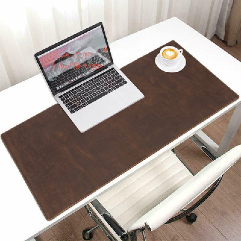 Brown leather desk mat with laptop and desk accessories