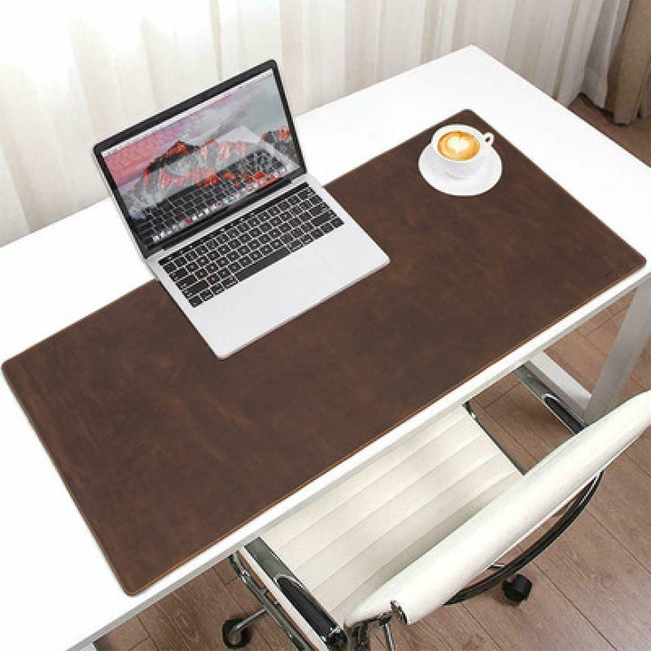 Brown leather desk mat with laptop and desk accessories