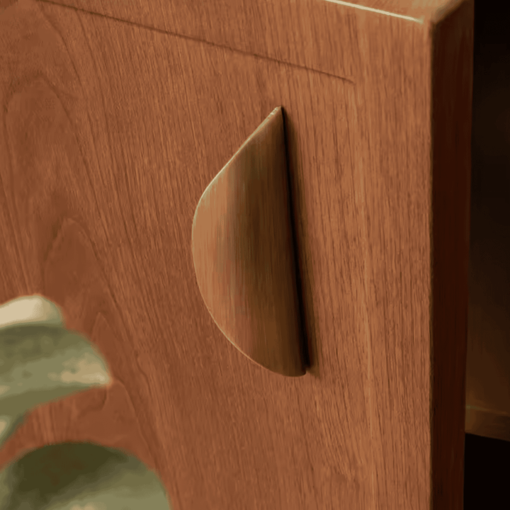 Crescent Brushed Brass Cabinet Pull on wood door close-up