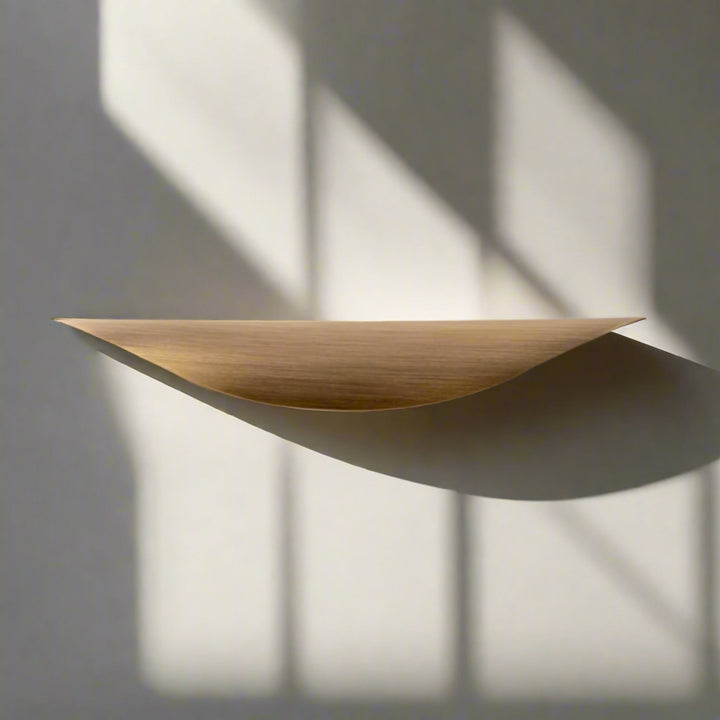Crescent Brushed Brass Cabinet Pull on drawer front in sunlight