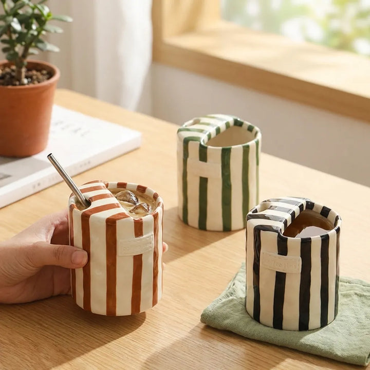 Black, Brown, and Green Retro Striped Ceramic Mugs on desk by window