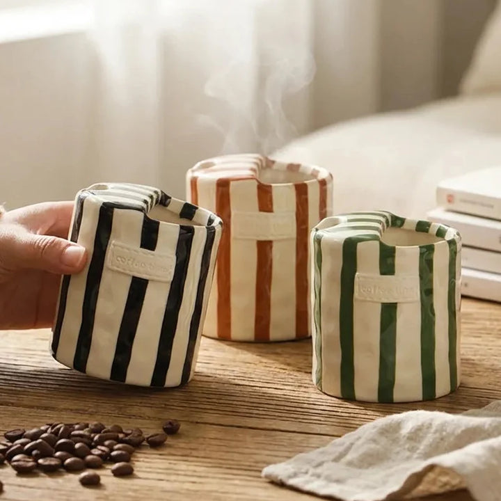 Black, Brown, and Green Retro Striped Ceramic Mugs on wooden table with steam