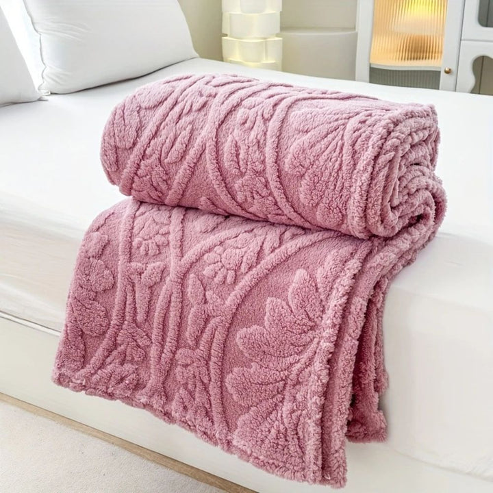 Blush Rose Embossed Plush Fleece Throw folded on a bed