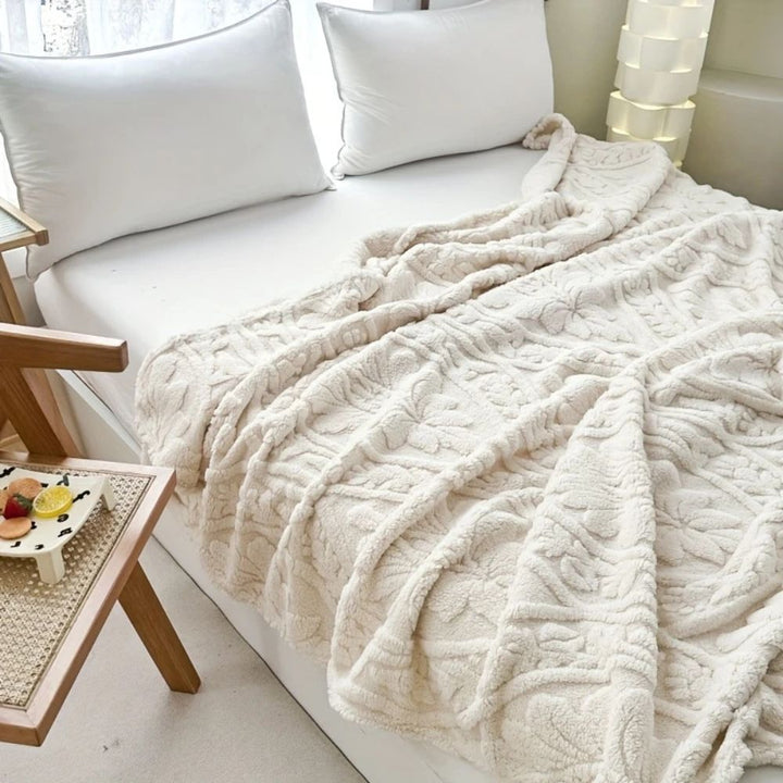 Ivory Cloud Embossed Plush Fleece Throw on a bed