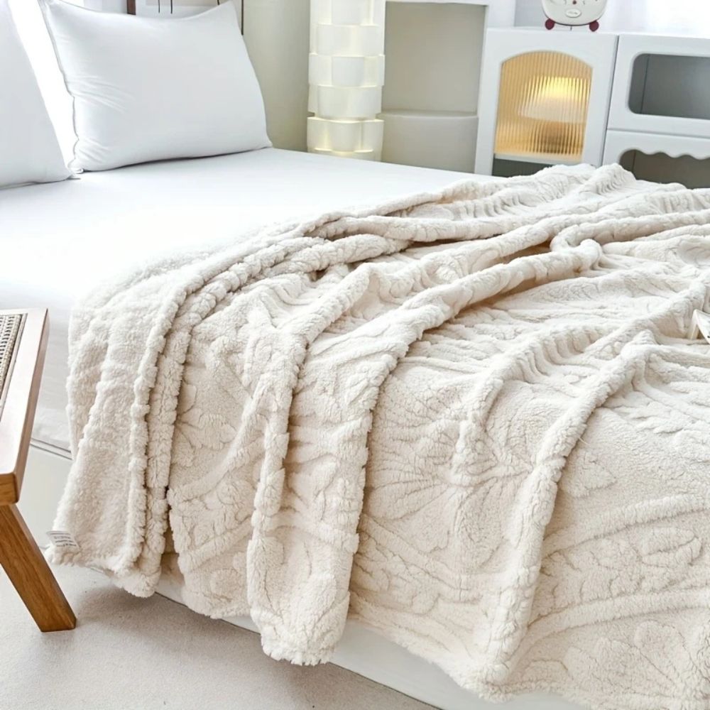 Ivory Cloud Embossed Plush Fleece Throw in a bedroom