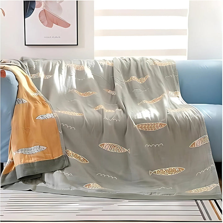 Sage Green Fish Jacquard Cotton Gauze Blanket draped over sofa