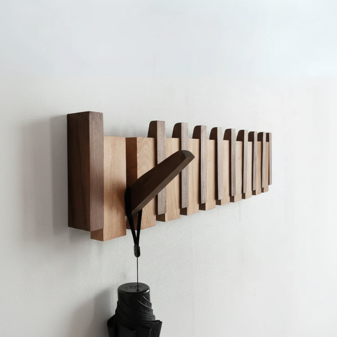 Folding wooden coat rack with hooks down holding a coat