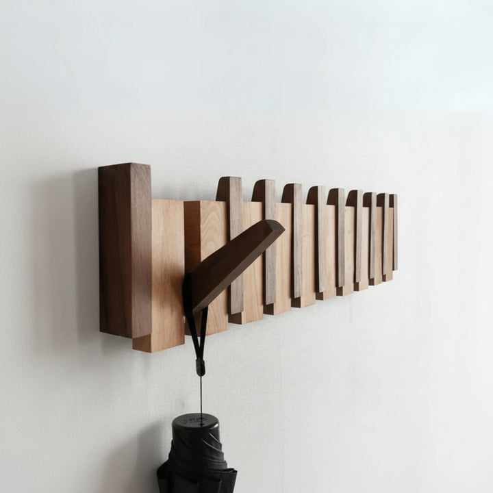 Folding wooden coat rack with hooks down holding a coat