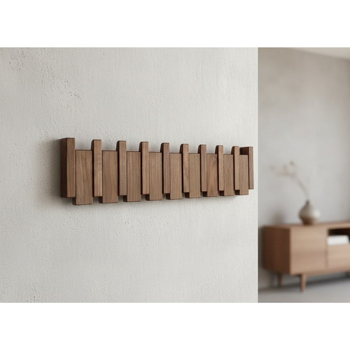 Folding wooden wall coat rack mounted above a bench