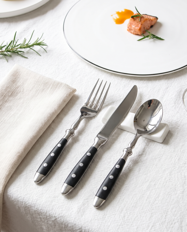 Elegant Black Stainless Steel Cutlery knife fork and spoon beside a plated dish