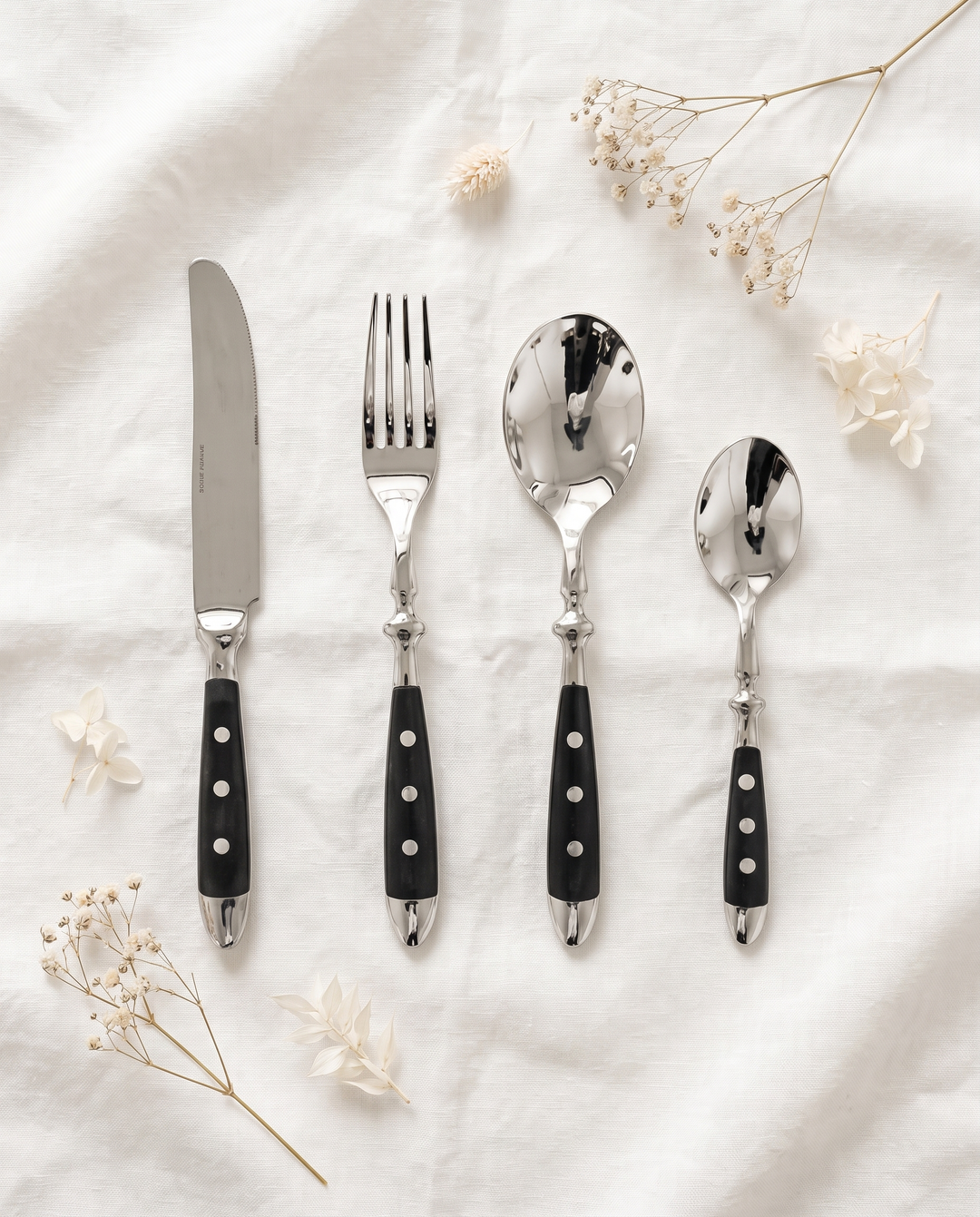 Elegant Black Stainless Steel Cutlery 4-piece set flat lay on linen