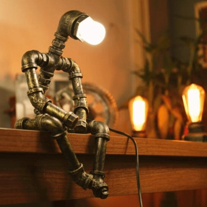 Adjustable Iron Robot Desk Lamp lit on desk