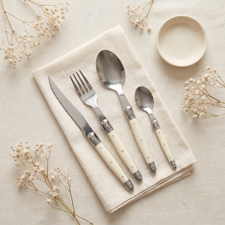 Ivory Handle Stainless Silverware Set 4-piece styled flat lay on linen