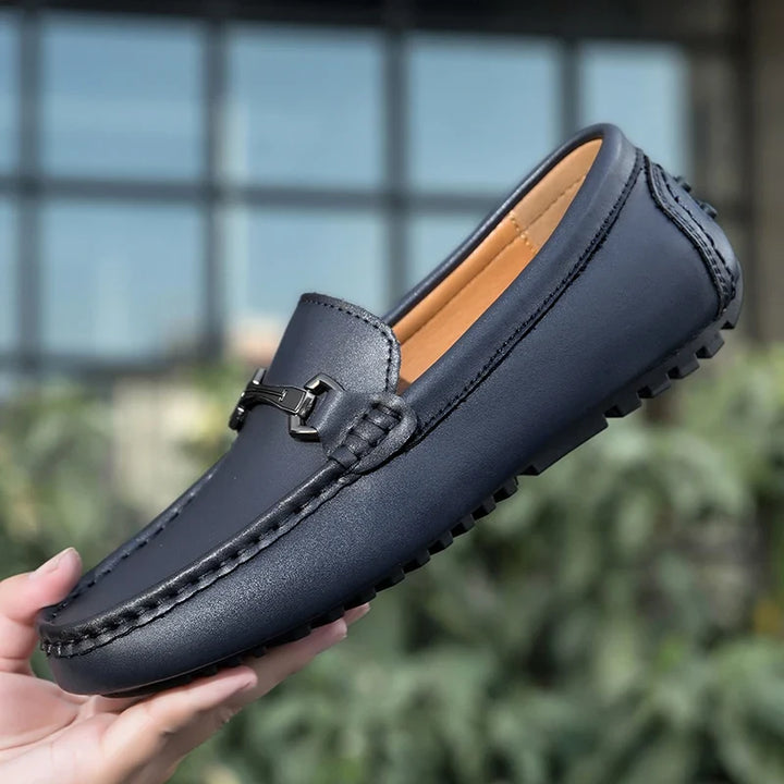 Blue Leather Driving Loafers held in hand