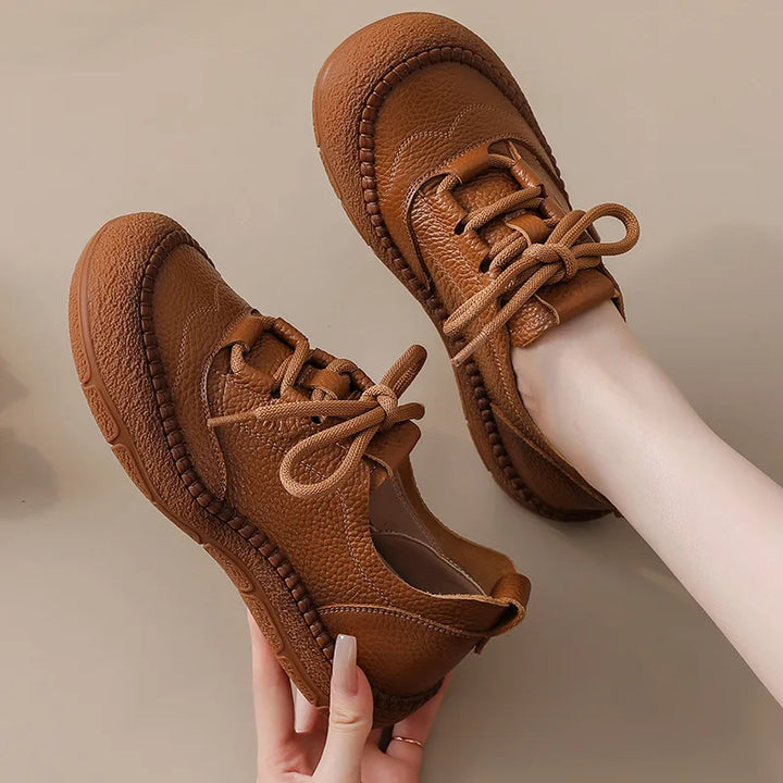 Brown Leather Platform Sneakers held in hand