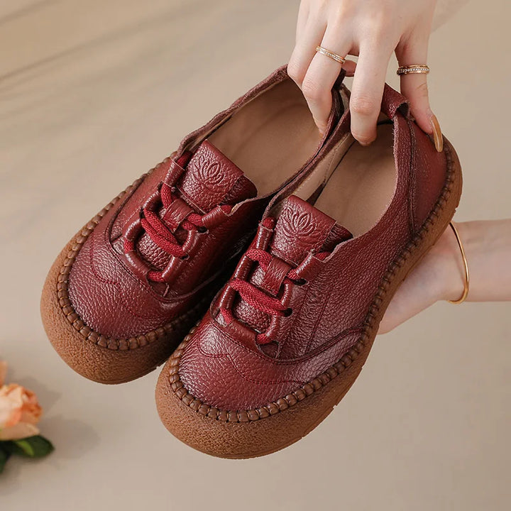 Burgundy Leather Platform Sneakers held in hand