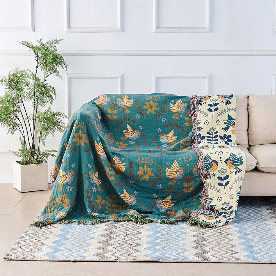 Nordic Bird Jacquard Cotton Throw draped over a bed
