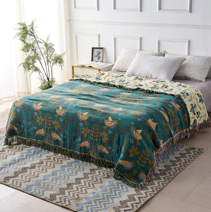 Nordic Bird Jacquard Cotton Throw covering a made bed