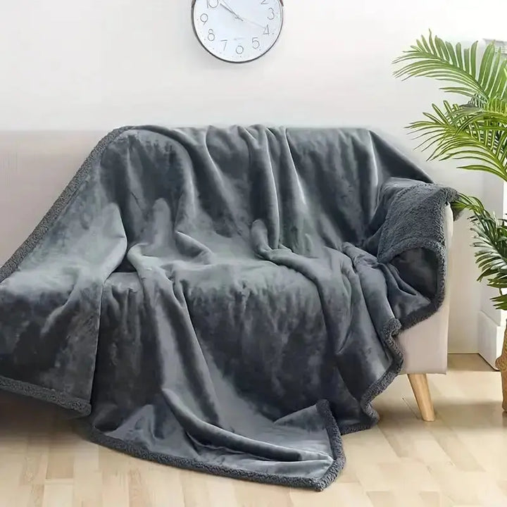 Gray Plush Waterproof Throw Blanket spread on a bed