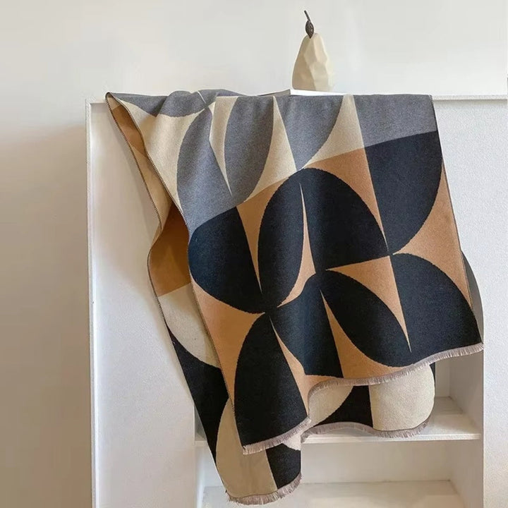 Charcoal and tan Reversible Geometric Poncho Blanket Scarf laid over chair