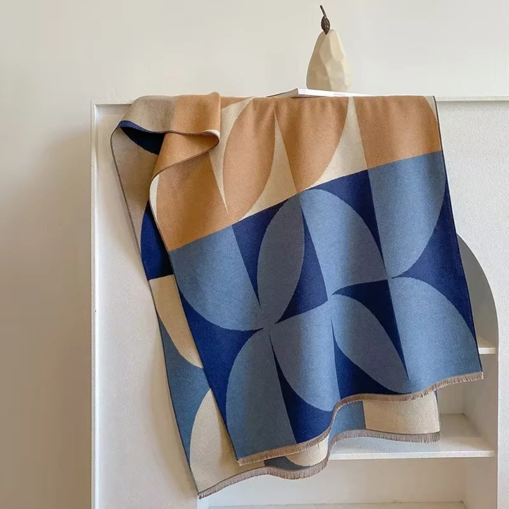 Blue and tan Reversible Geometric Poncho Blanket Scarf laid over chair