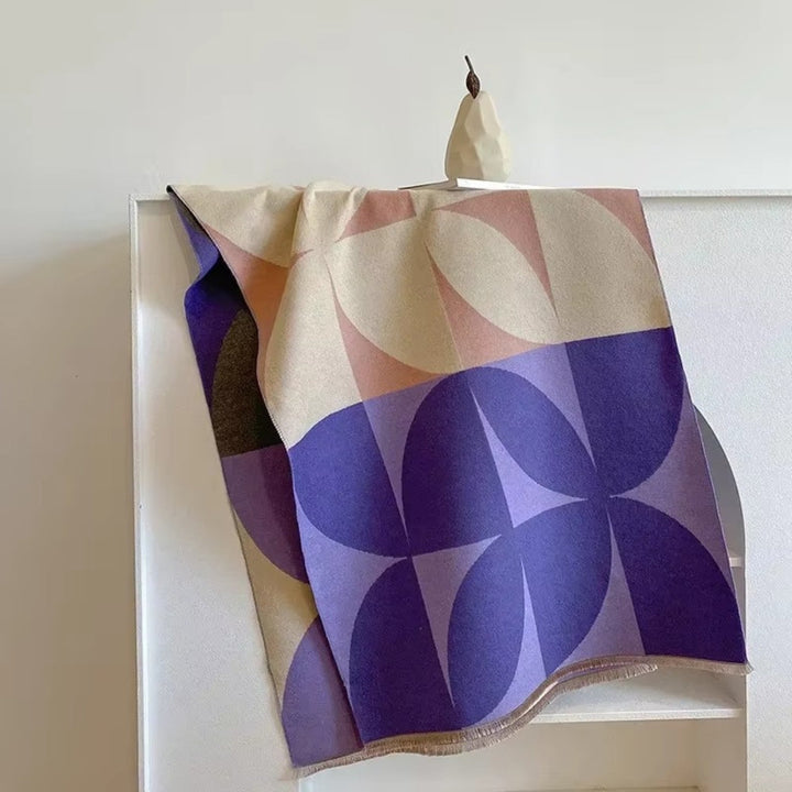Lavender and purple Reversible Geometric Poncho Blanket Scarf laid over chair