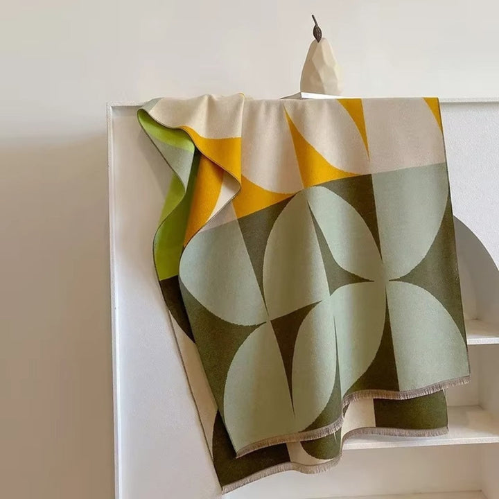 Green and yellow Reversible Geometric Poncho Scarf laid over chair