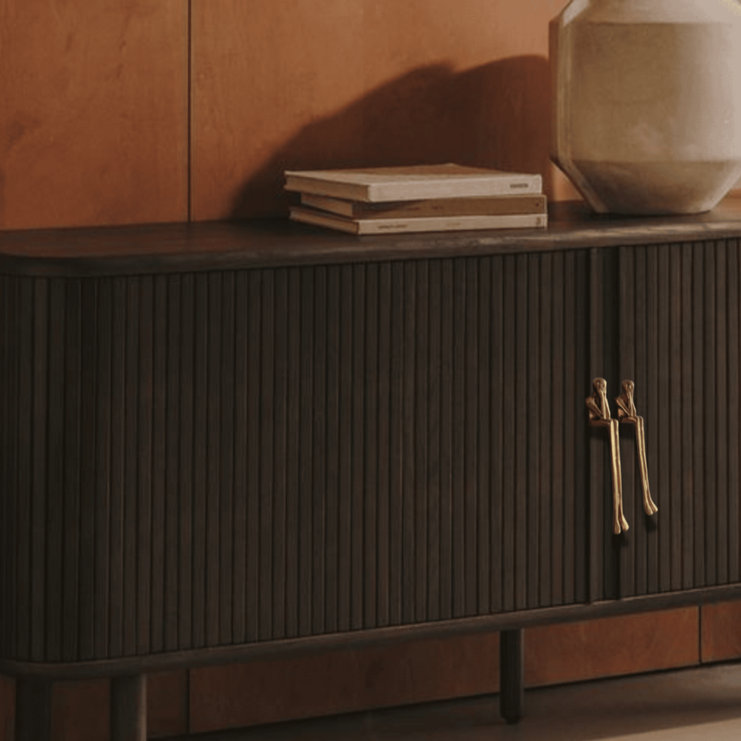 Gold Sculptural Figure Brass Cabinet Pulls on dark sideboard