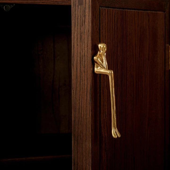 Gold Sculptural Figure Brass Cabinet Pull on walnut door close-up